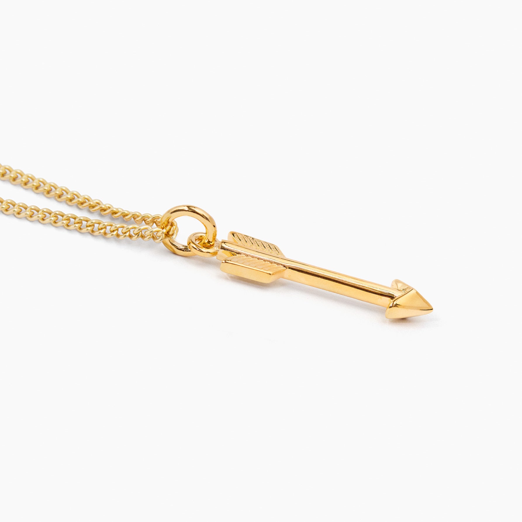 Gold arrow pendant on fine curb chain, close-up with loop and arrow tip