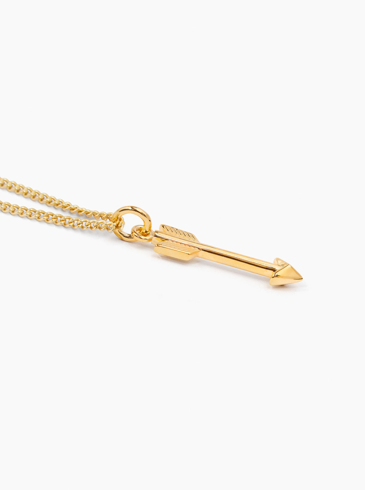 Gold arrow pendant on fine curb chain, close-up with loop and arrow tip
