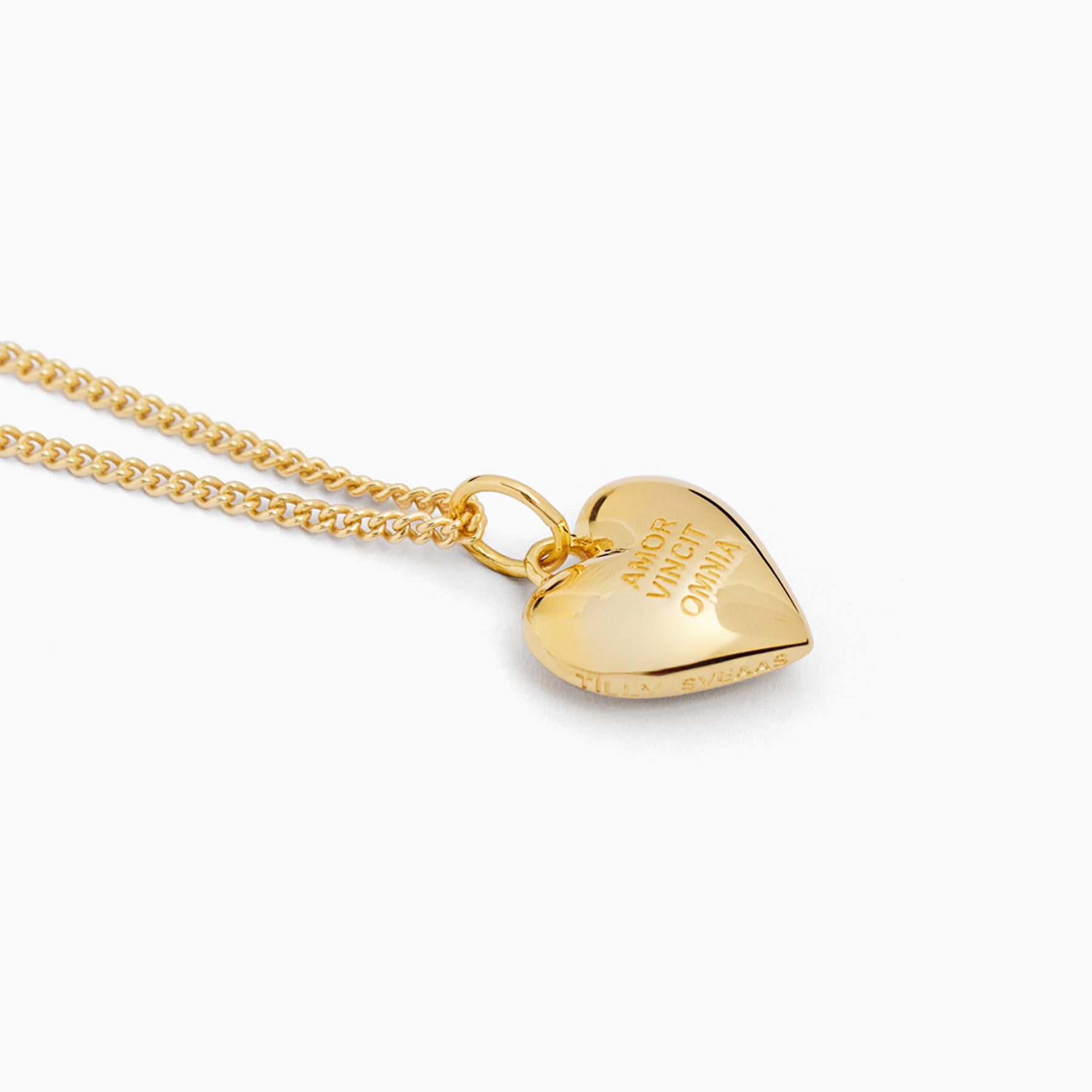 Gold heart pendant on fine curb chain with engraved message on front, side view