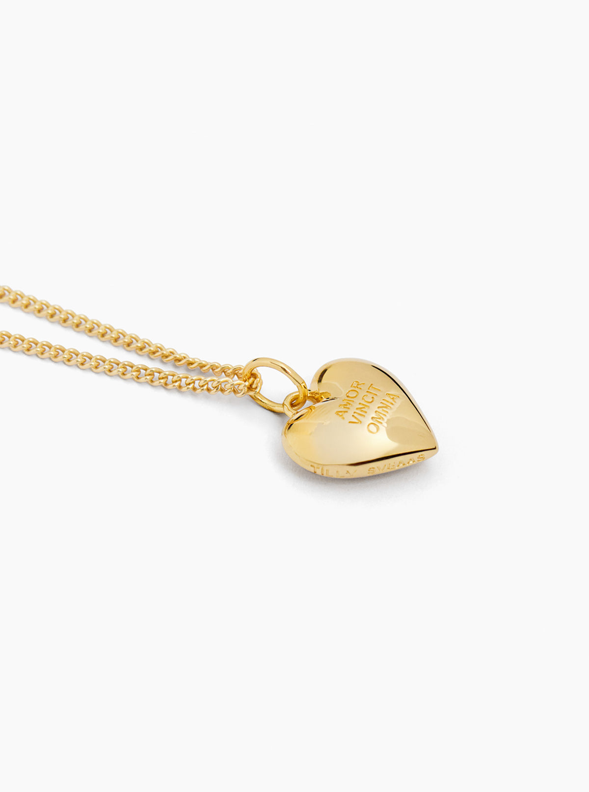 Gold heart pendant on fine curb chain with engraved message on front, side view