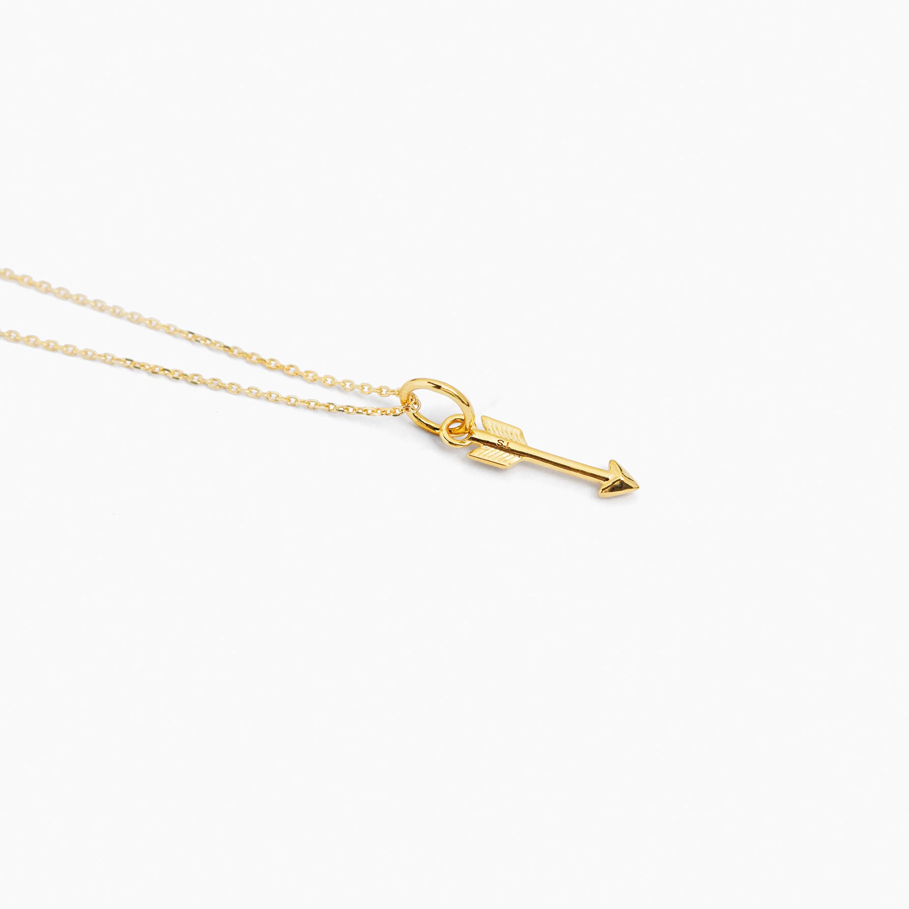 Small gold arrow pendant necklace on thin trace chain