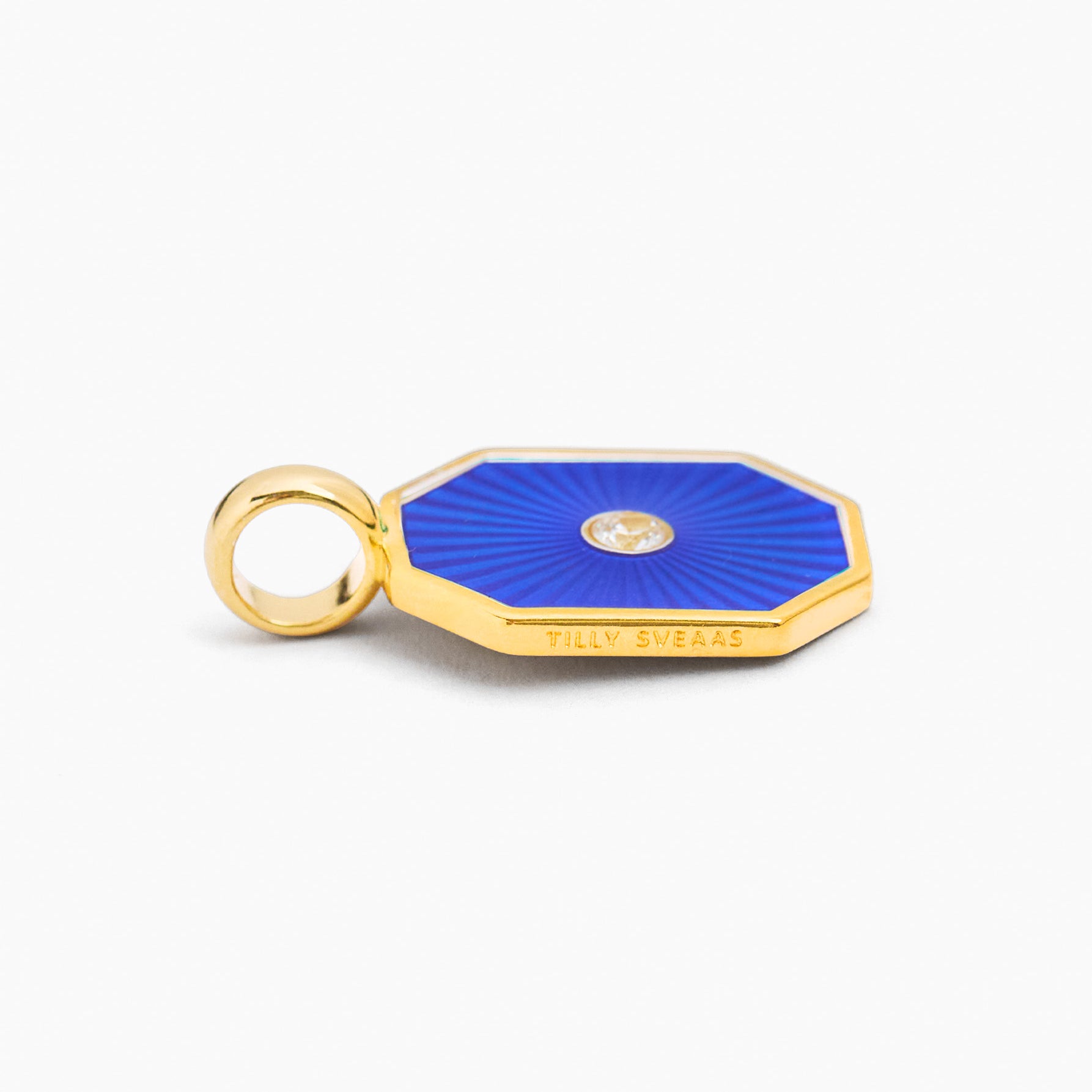 Gold-tone octagon charm with navy blue enamel and small round gem, with loop bail
