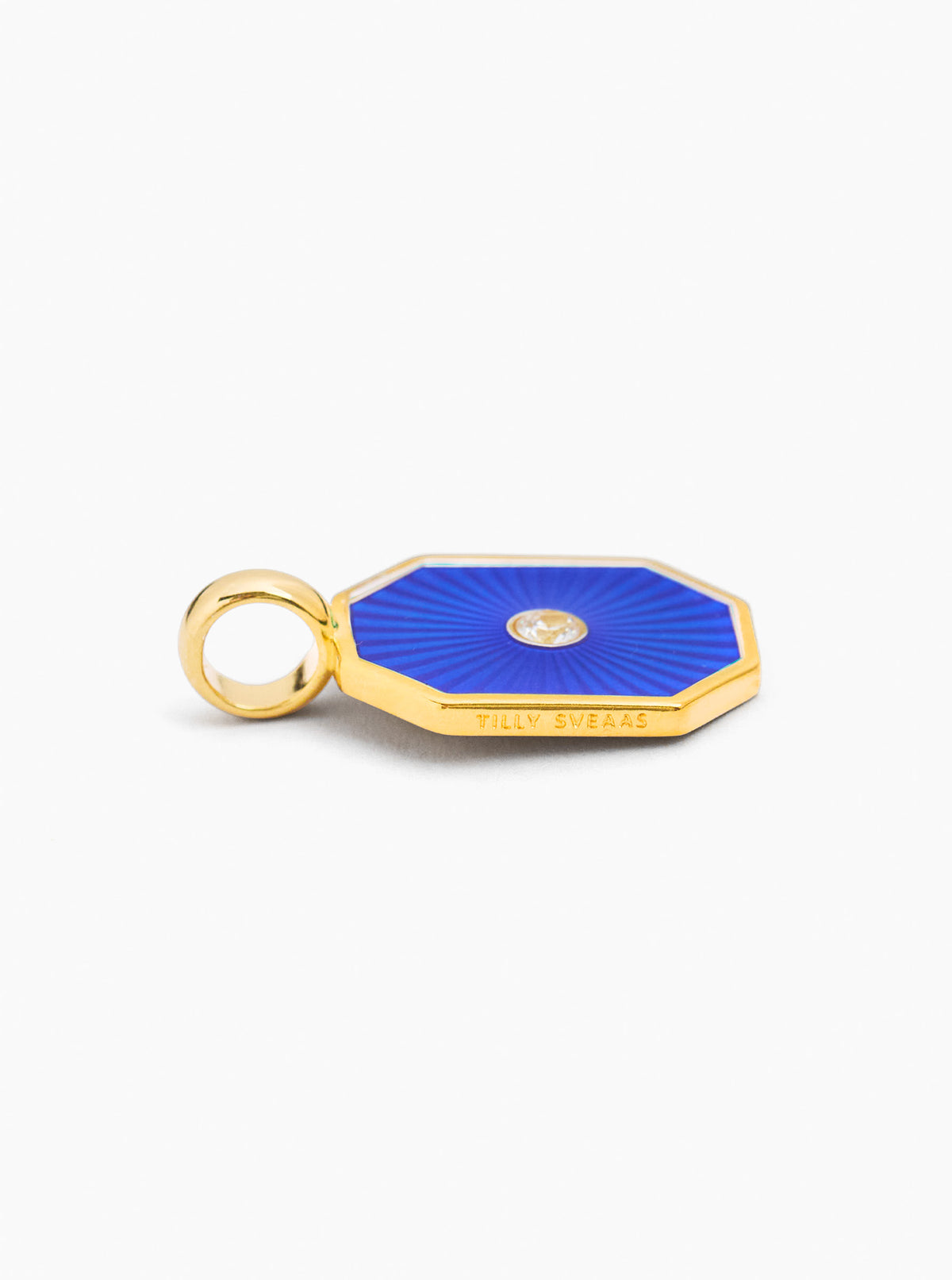 Gold-tone octagon charm with navy blue enamel and small round gem, with loop bail