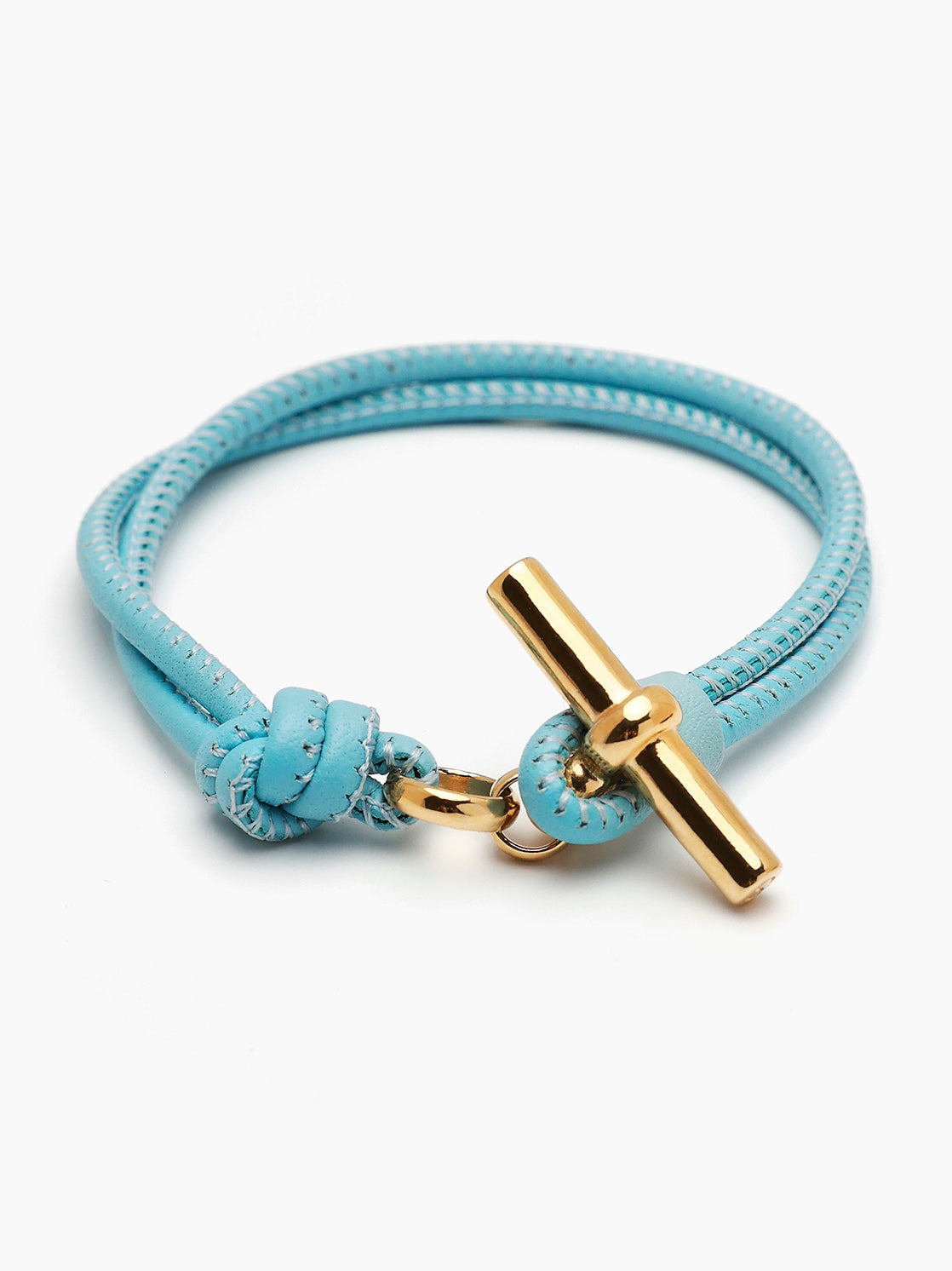 Pale blue leather bracelet with gold T-bar clasp and braided strap detail