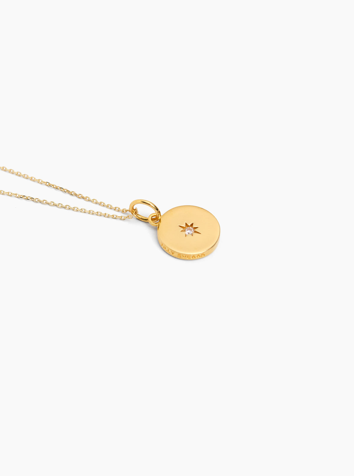 Gold disc pendant on trace chain with star-like jeweled center