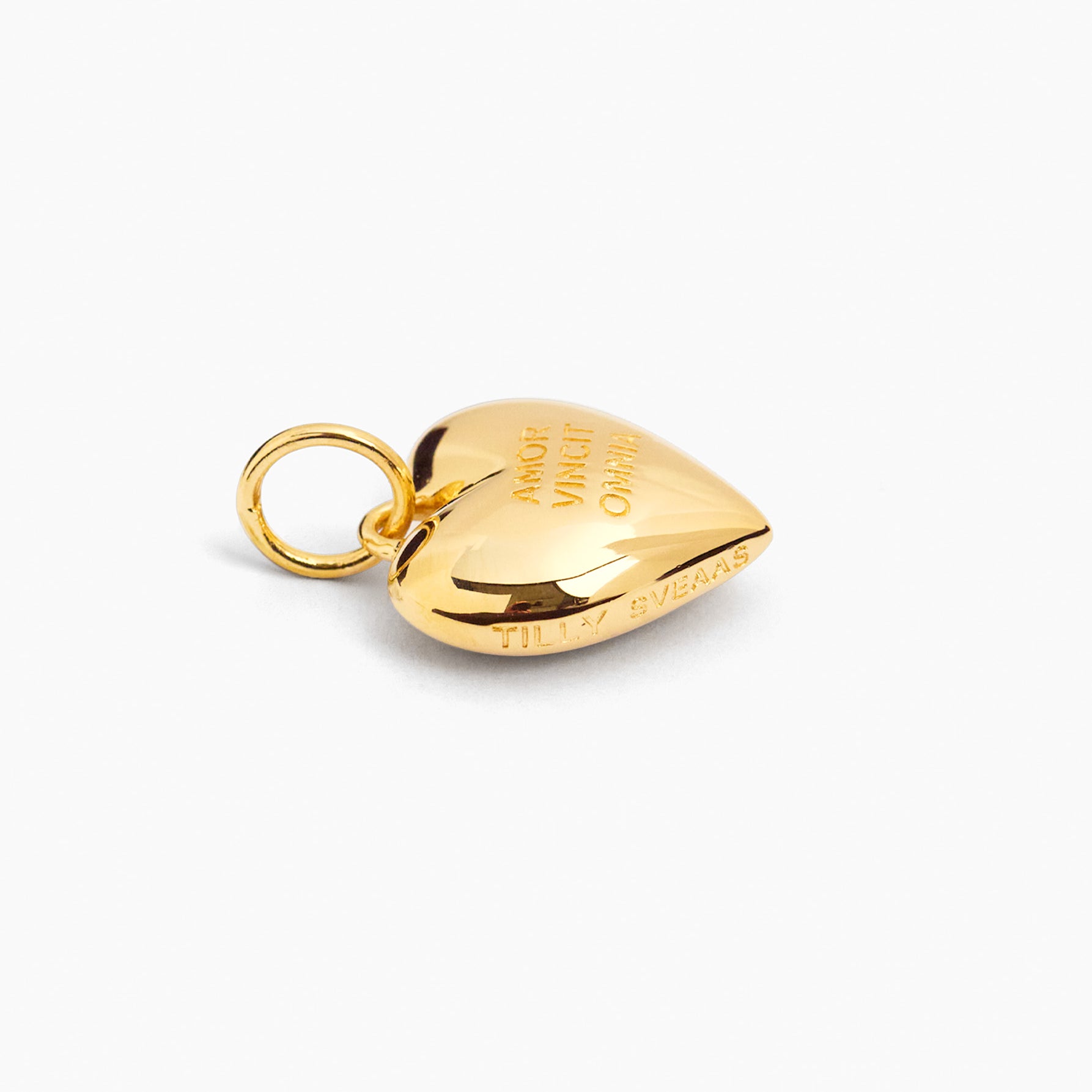 Gold heart-shaped charm with attached loop ring and engraved message