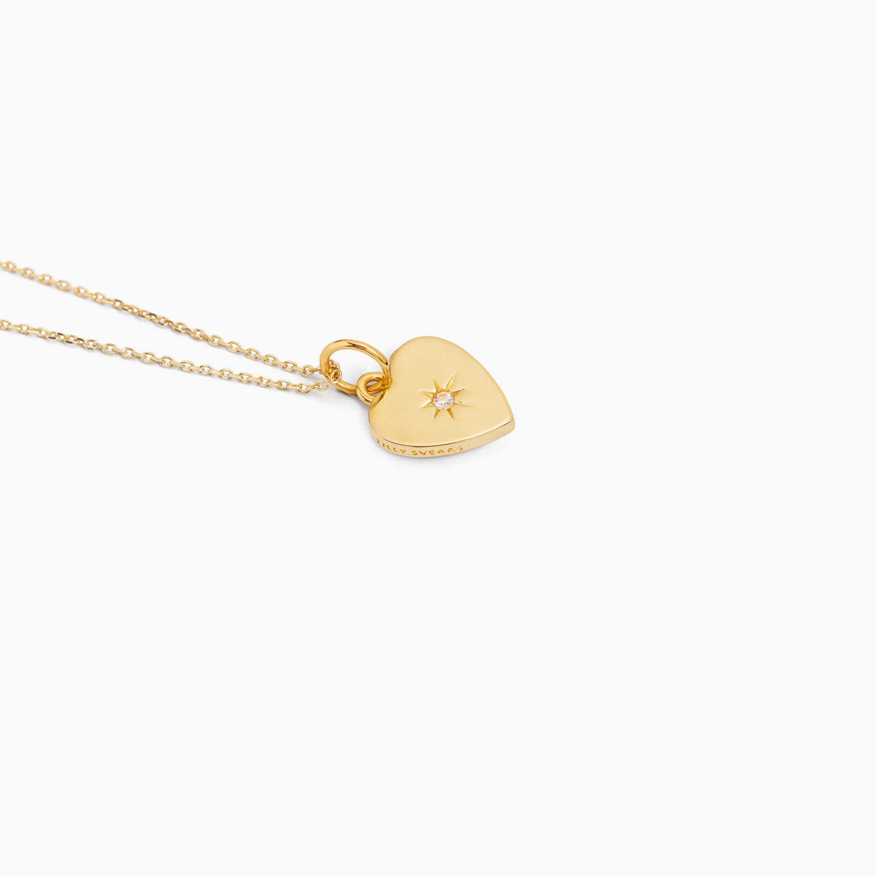 Gold heart pendant necklace on trace chain with star jeweled detail