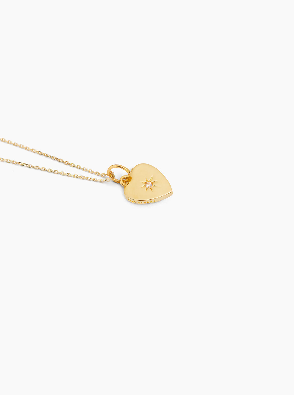 Gold heart pendant necklace on trace chain with star jeweled detail
