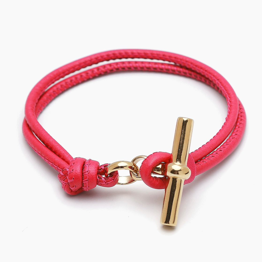 Pink leather bracelet with gold T-bar charm and clasp loop detail