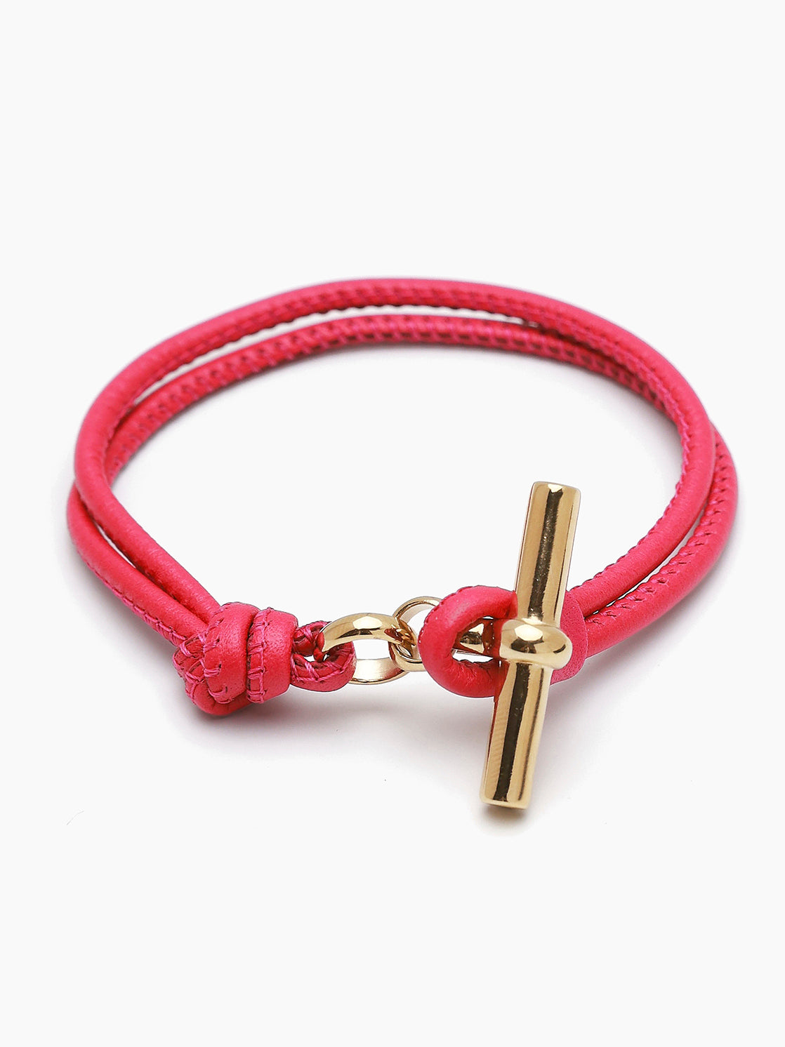 Pink leather bracelet with gold T-bar charm and clasp loop detail