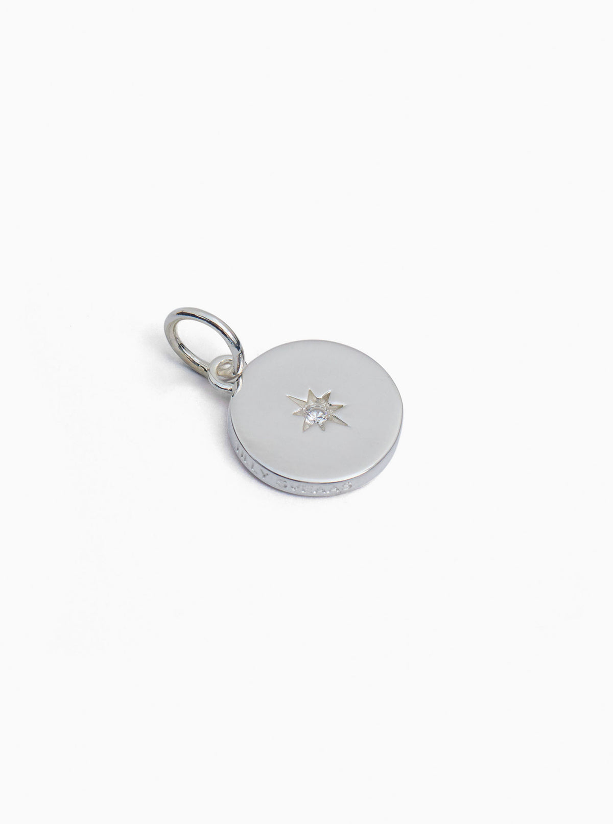 Silver jeweled disc charm with centered star detail and small loop clasp