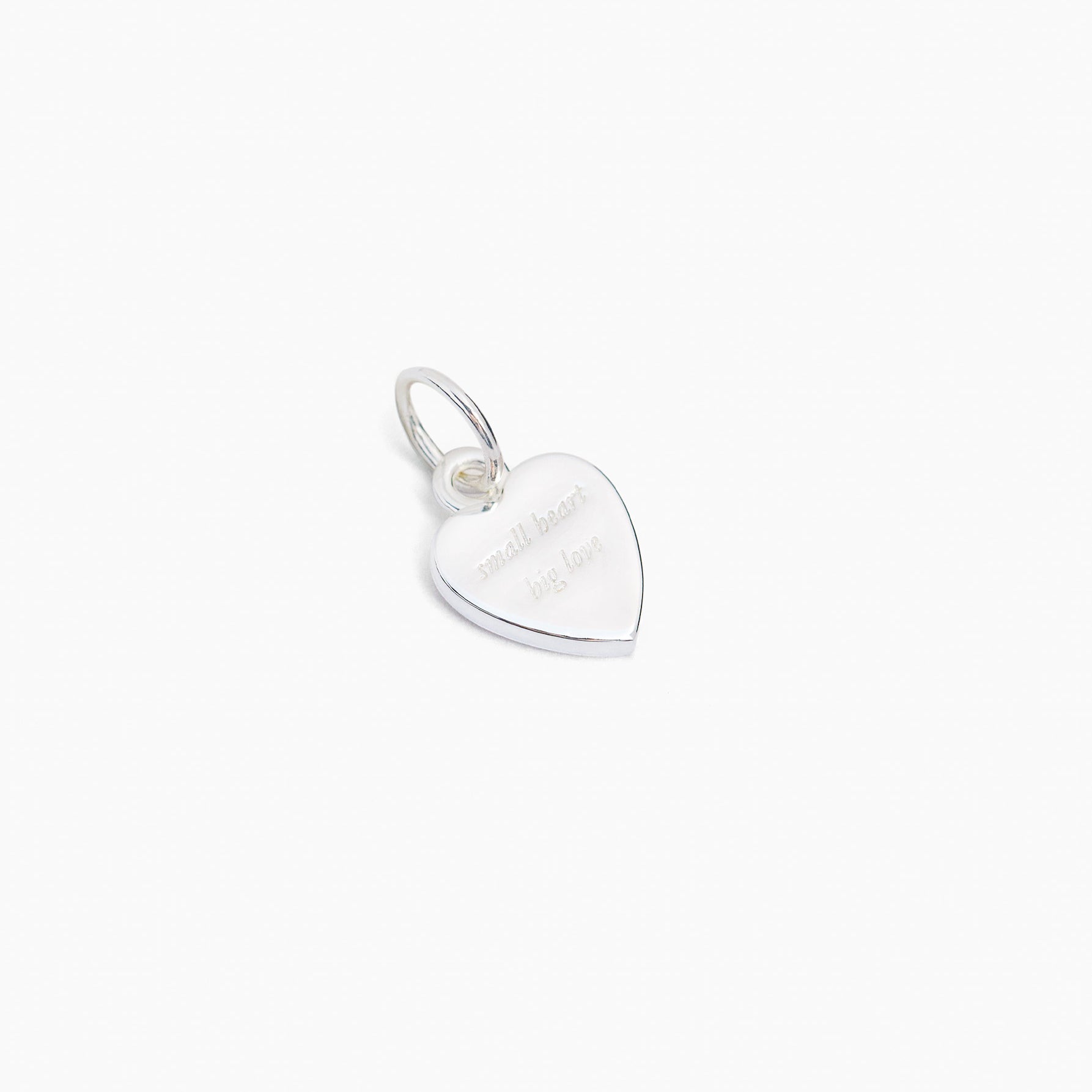Small silver heart charm with flat back and hanging loop, jeweled detail on front