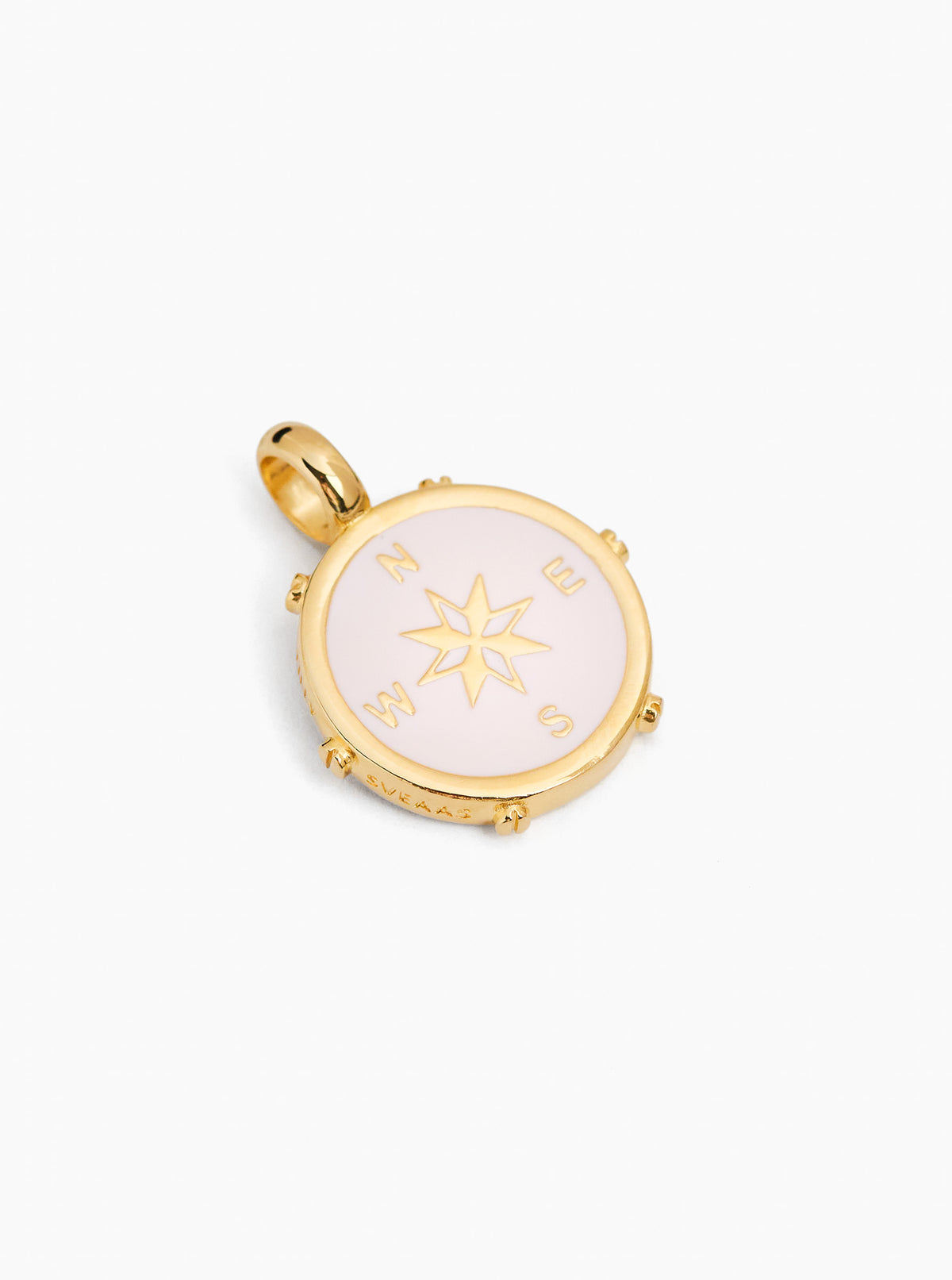 Gold-tone compass charm with cream enamel front, star compass design, small outer studs, bail