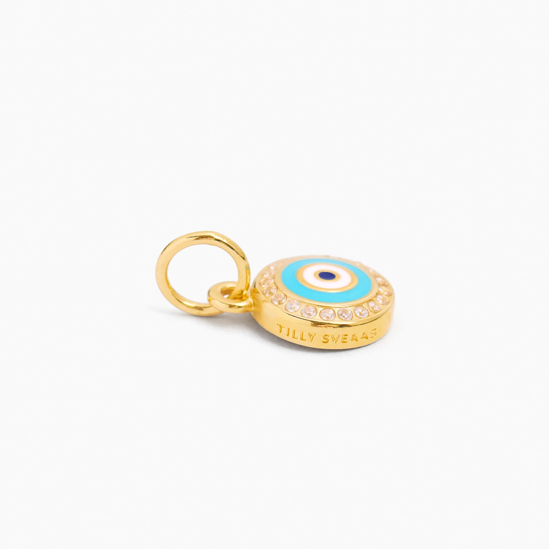 Gold evil eye disc charm with blue enamel center and ring bail; engraved band visible