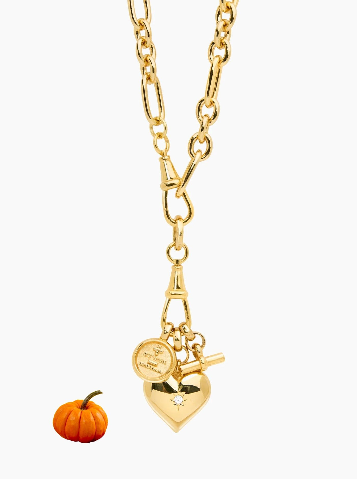 Gold-tone chain necklace with a heart pendant, toggle clasp, and small dangling charms