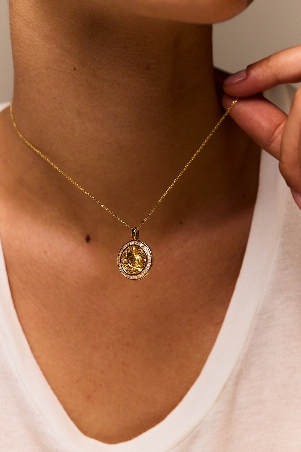 Gold round Buddha medallion pendant necklace with trace chain, worn