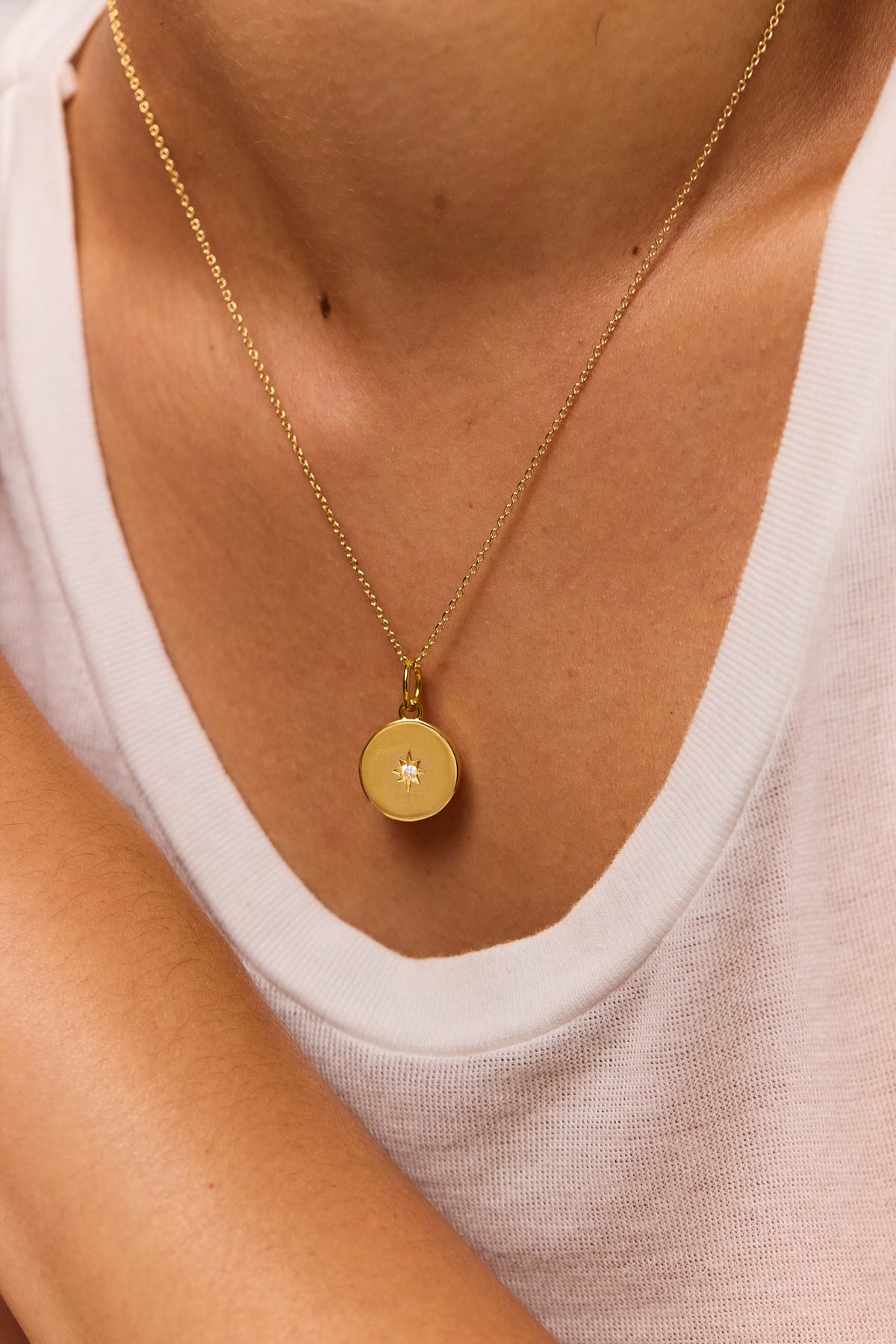 Gold disc pendant necklace on fine trace chain, round charm with jewel detail