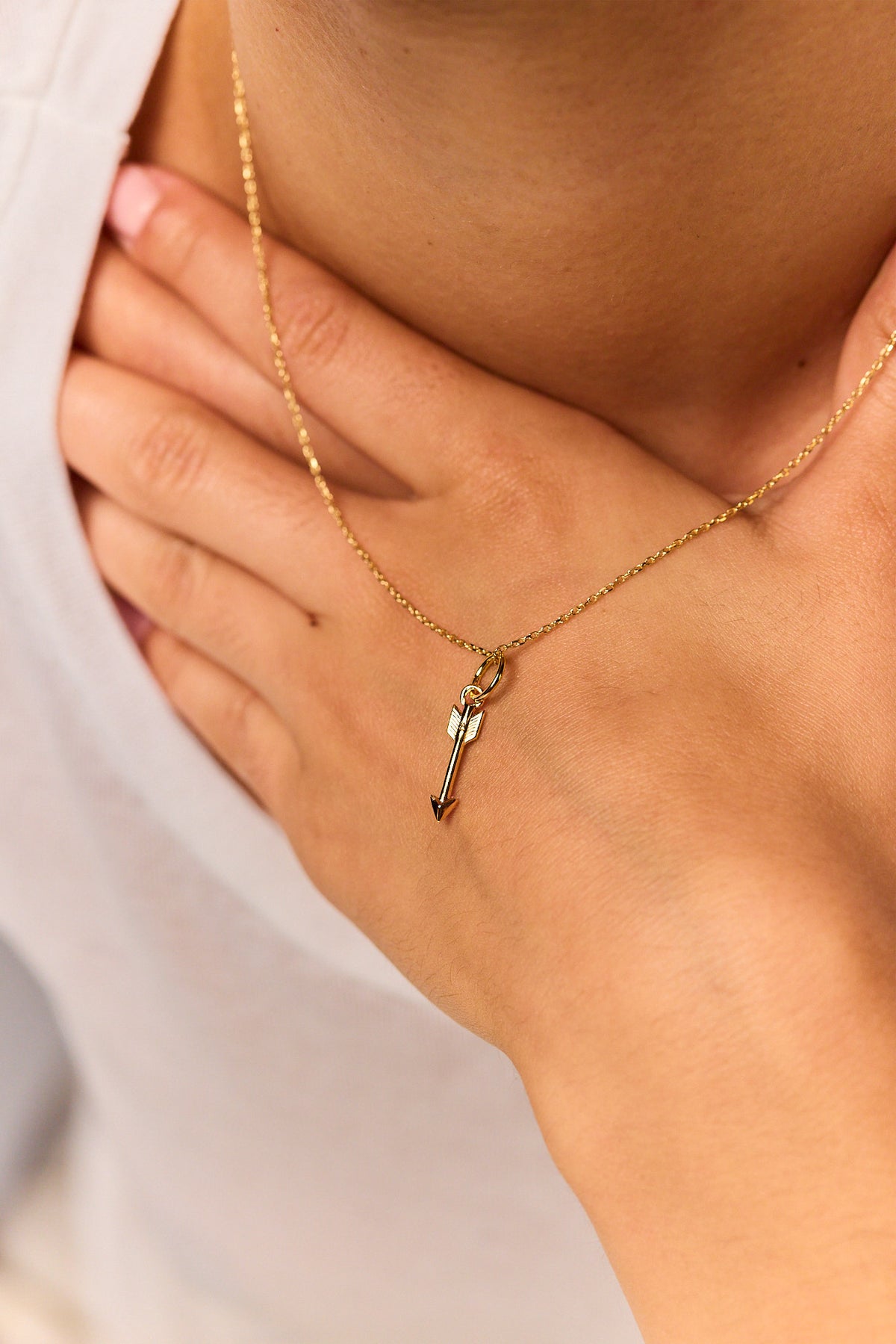 Gold arrow pendant on fine trace chain, small V-shaped charm detail