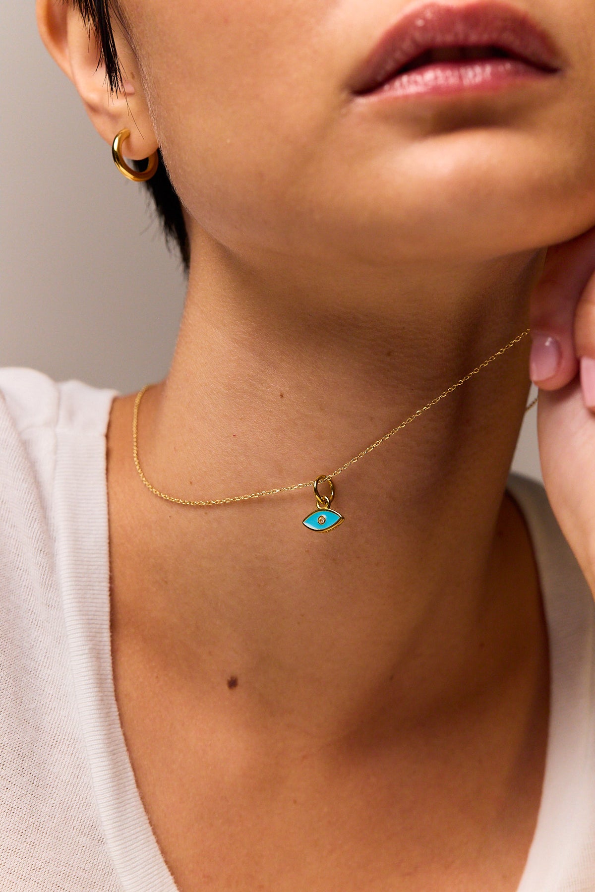 Gold-tone trace chain necklace with small turquoise evil eye pendant