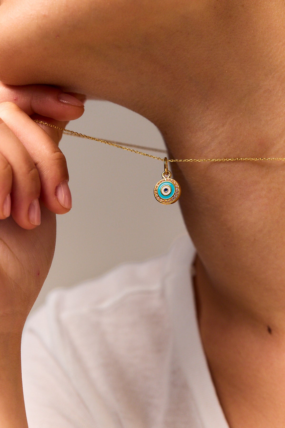 Gold trace chain necklace with evil eye disc pendant, small round blue center