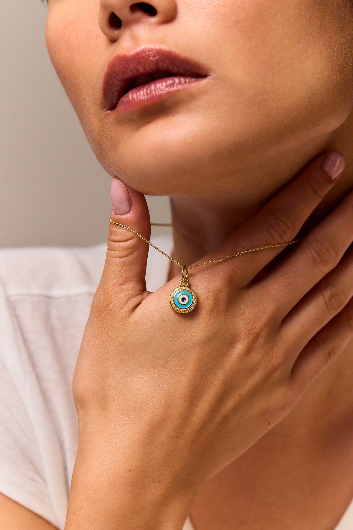 Evil eye disc pendant necklace on gold chain, blue jeweled center on disc