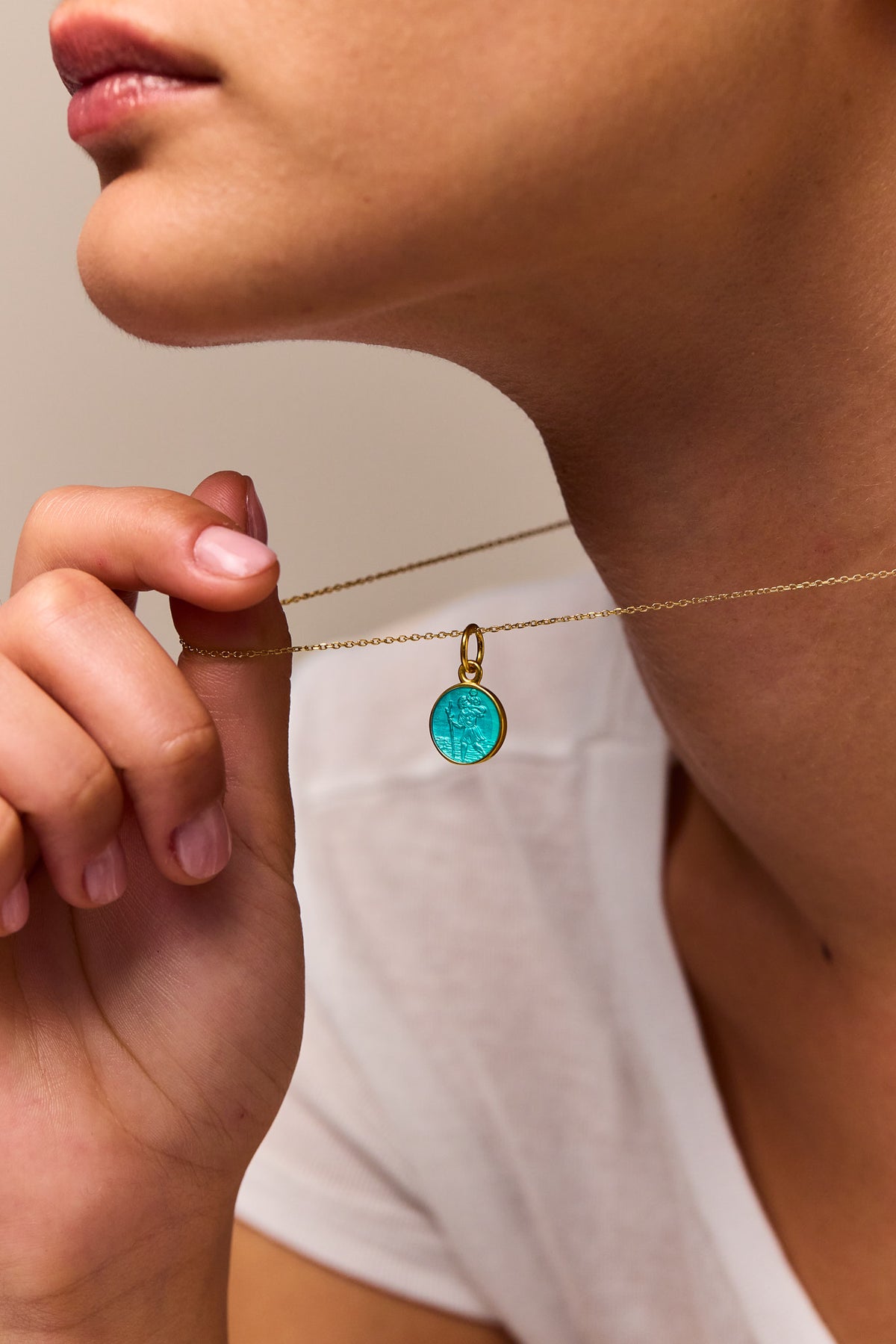Gold trace chain necklace with turquoise circular pendant, worn by model