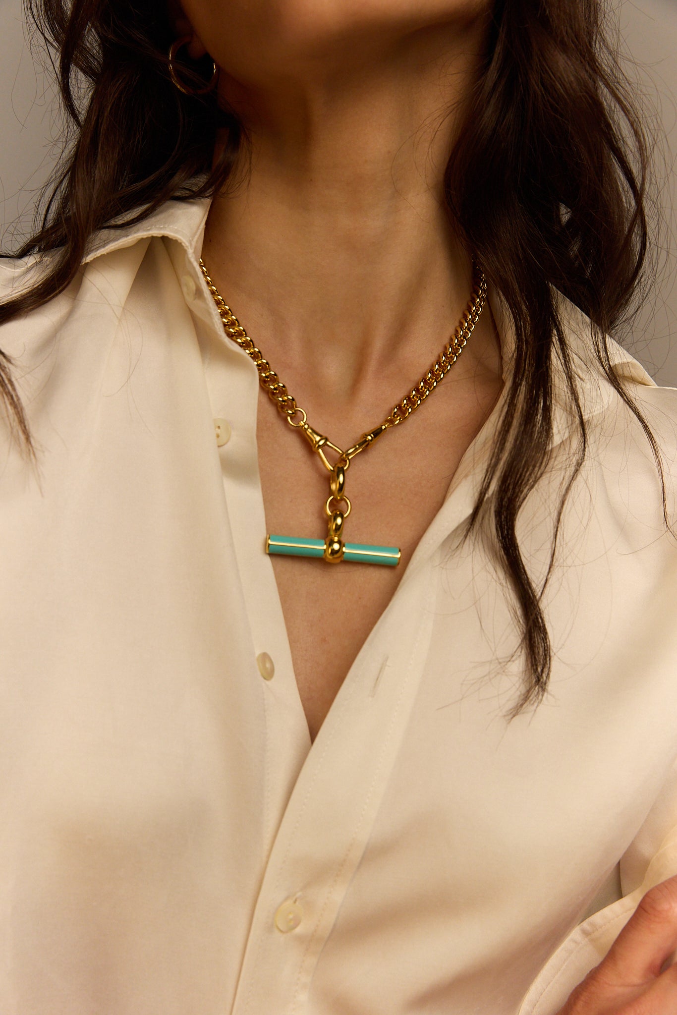 Mint enamel T-bar pendant on gold chain necklace at chest close-up
