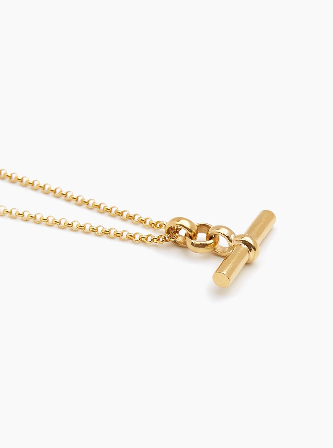 Gold necklace with a cylindrical t bar pendant on a white background - Tilly Sveaas Jewellery 