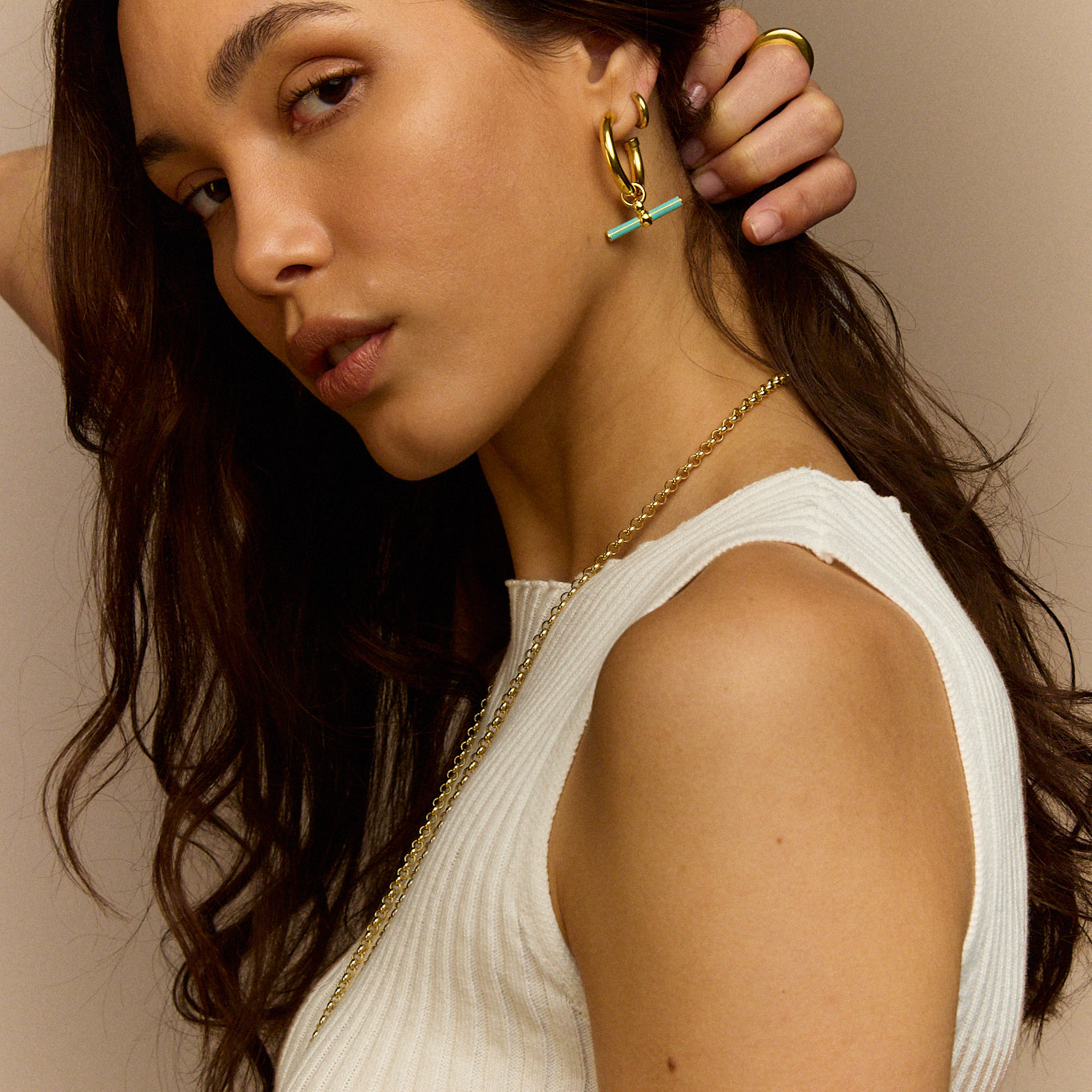 Gold T-bar earrings with mint enamel bar charm on model’s ear