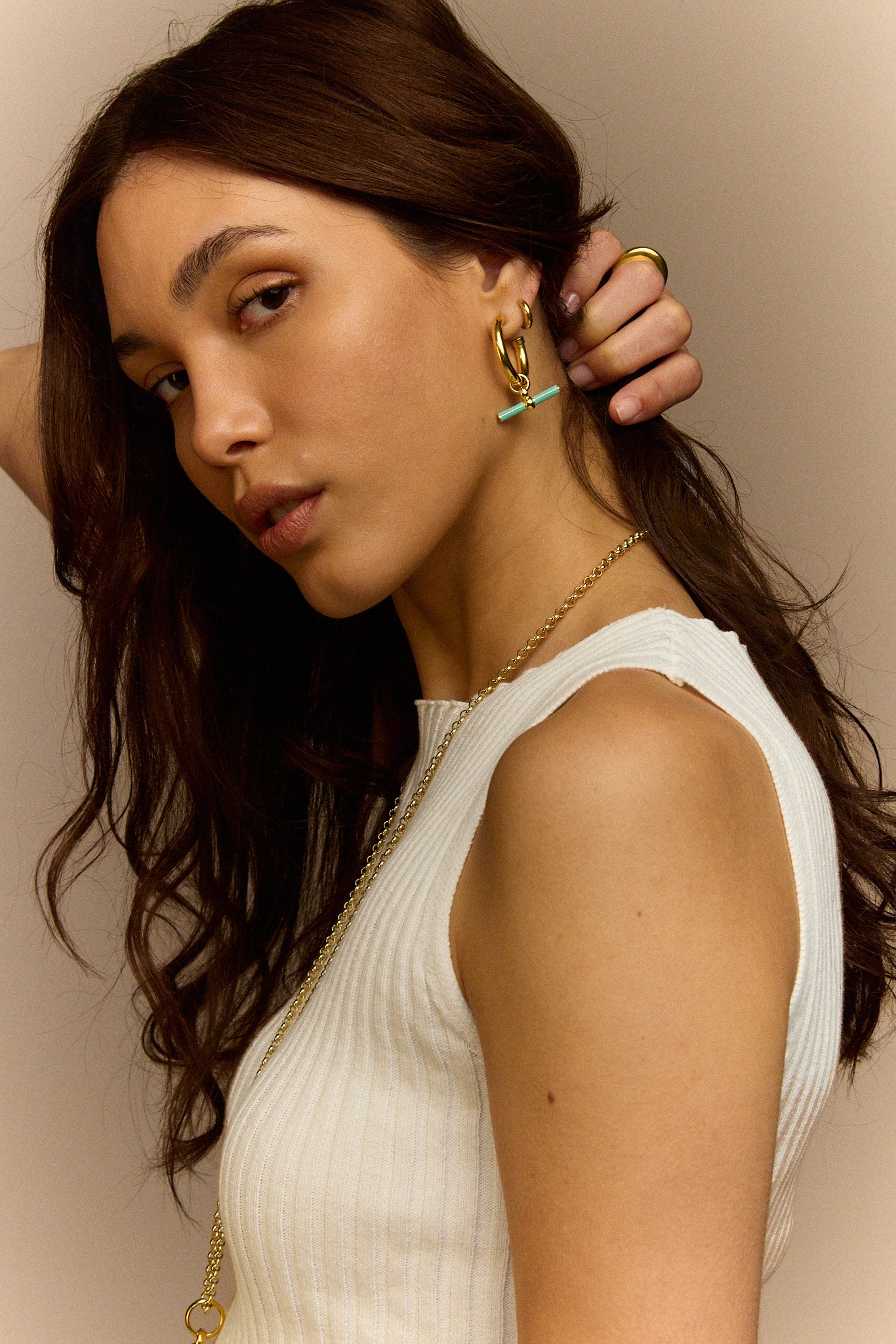 Gold T-bar earrings with mint enamel bar charm on model’s ear