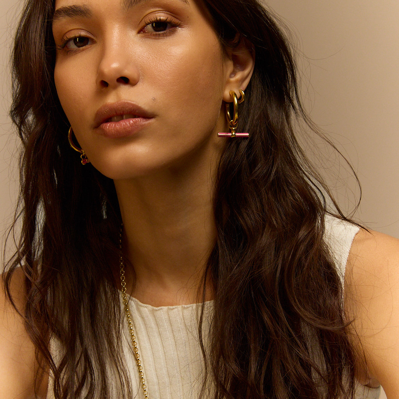 Gold hoop earrings with pink enamel bar charm
