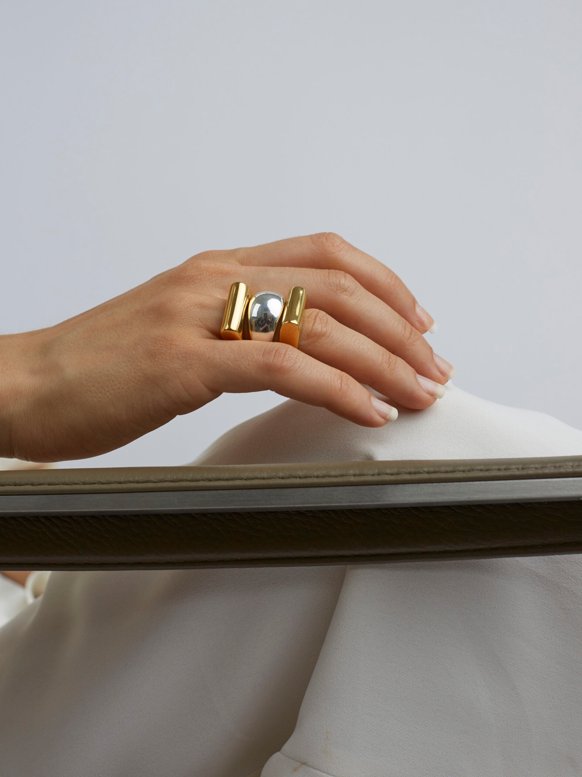 Gold and silver stacked triple rings on hand, ridged band design