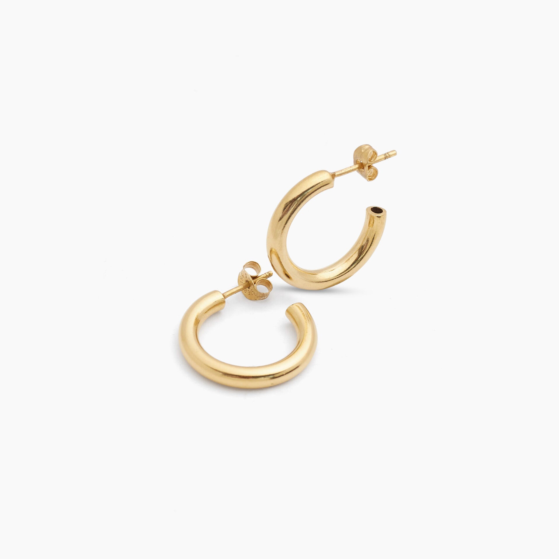 Small gold hoop earrings, angled close-up of pair with post attachments