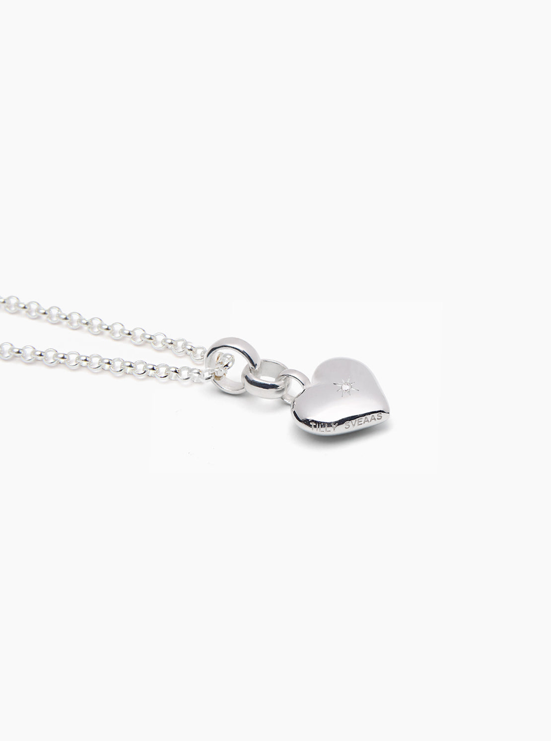 Silver chain necklace with small heart pendant and clasp detail, close-up view.