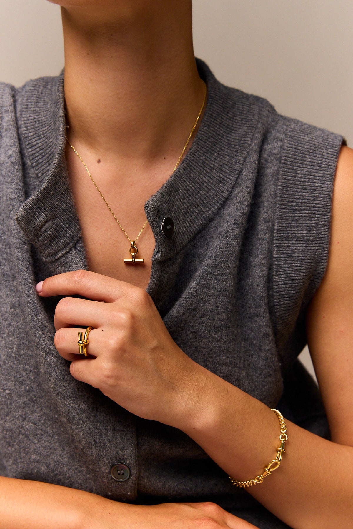 Gold mini T-bar pendant on trace chain necklace, layered on neckline