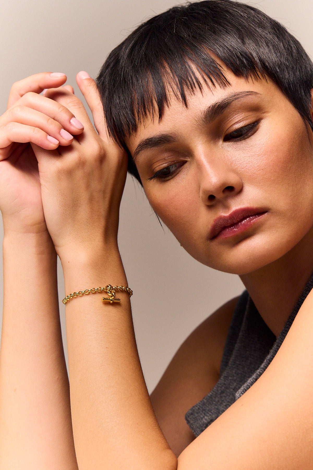 Gold chain bracelet with small T-bar charm on wrist