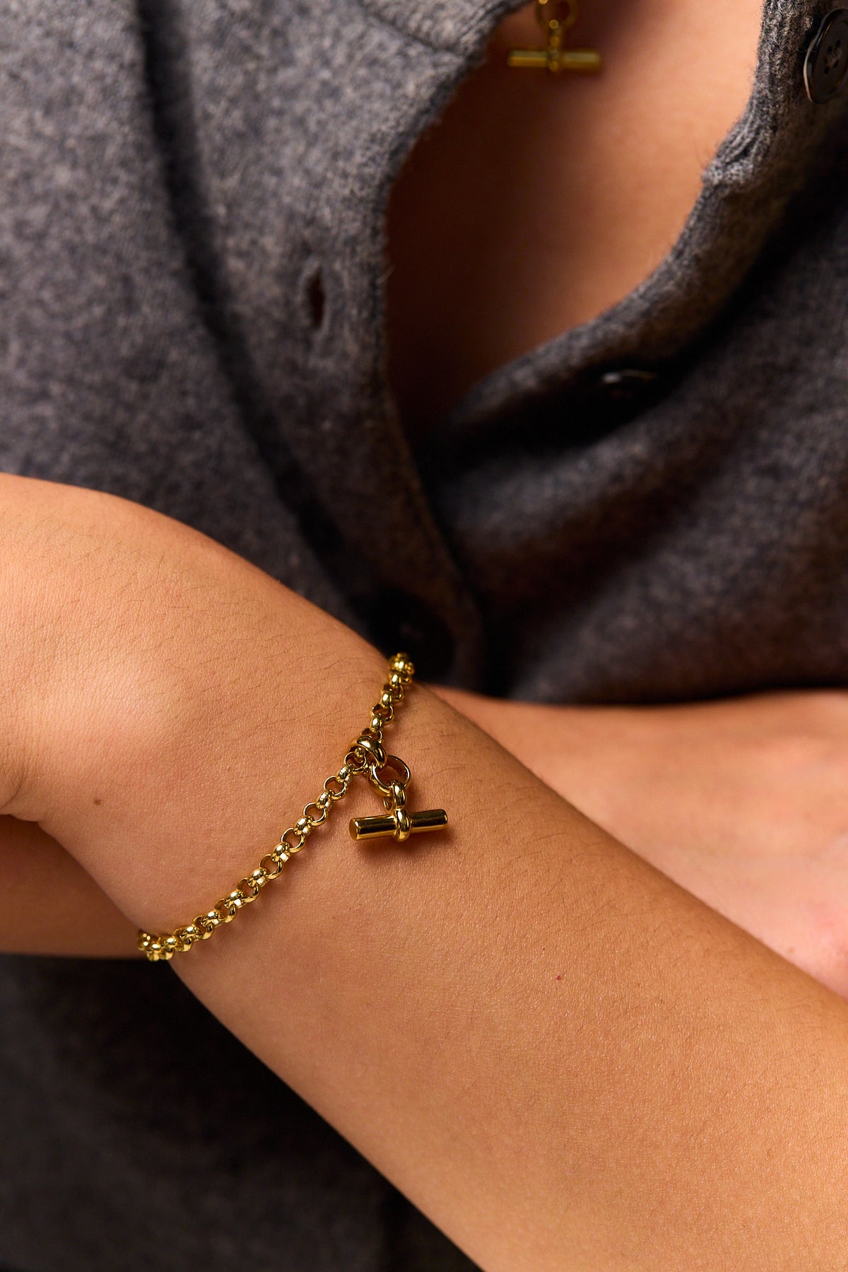 Gold belcher bracelet with mini T-bar charm on wrist