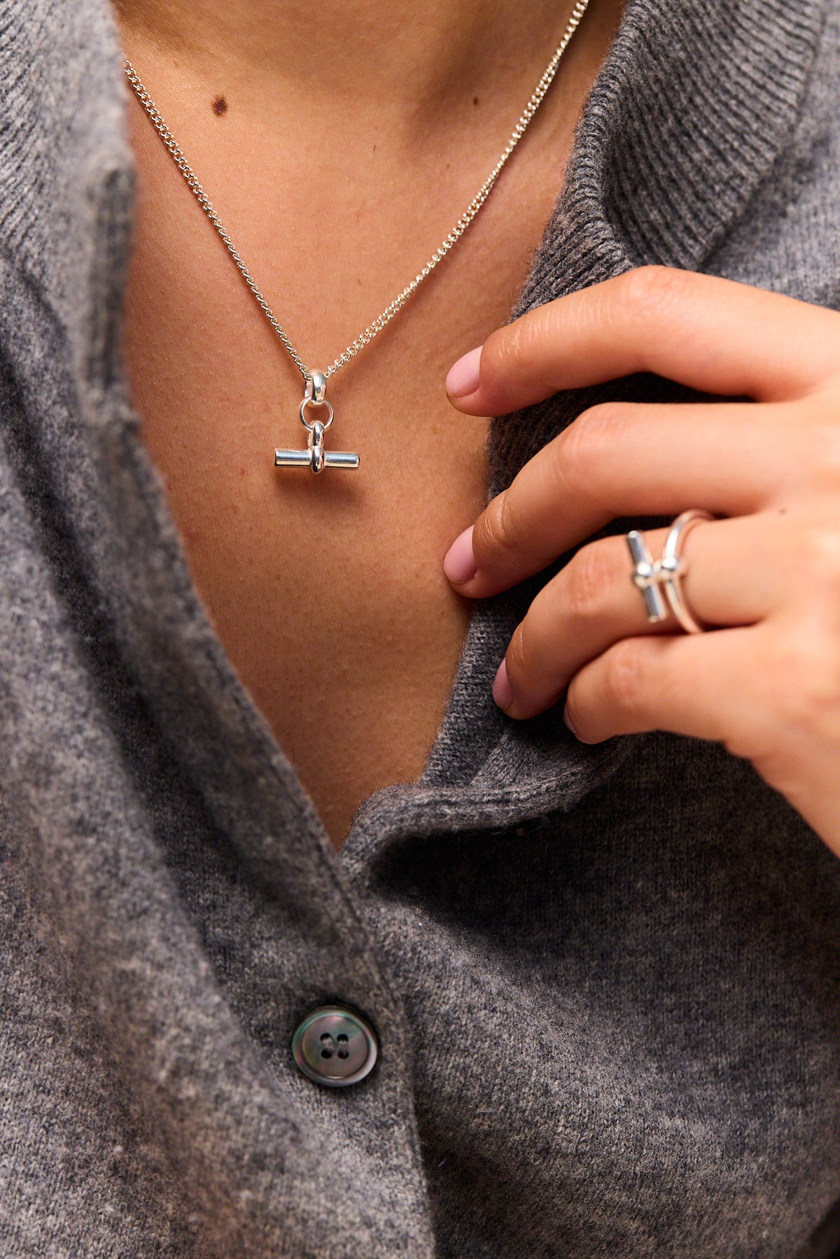 Mini silver T-bar pendant on fine curb chain necklace, close-up view