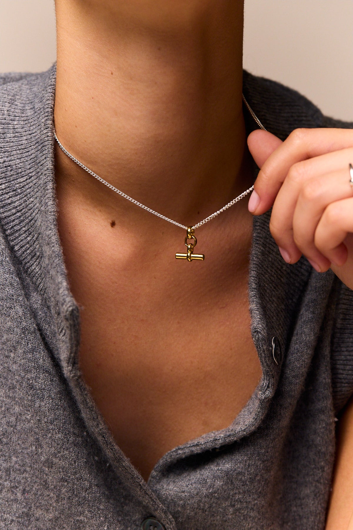 Fine silver curb chain necklace with mini gold T-bar charm near neckline