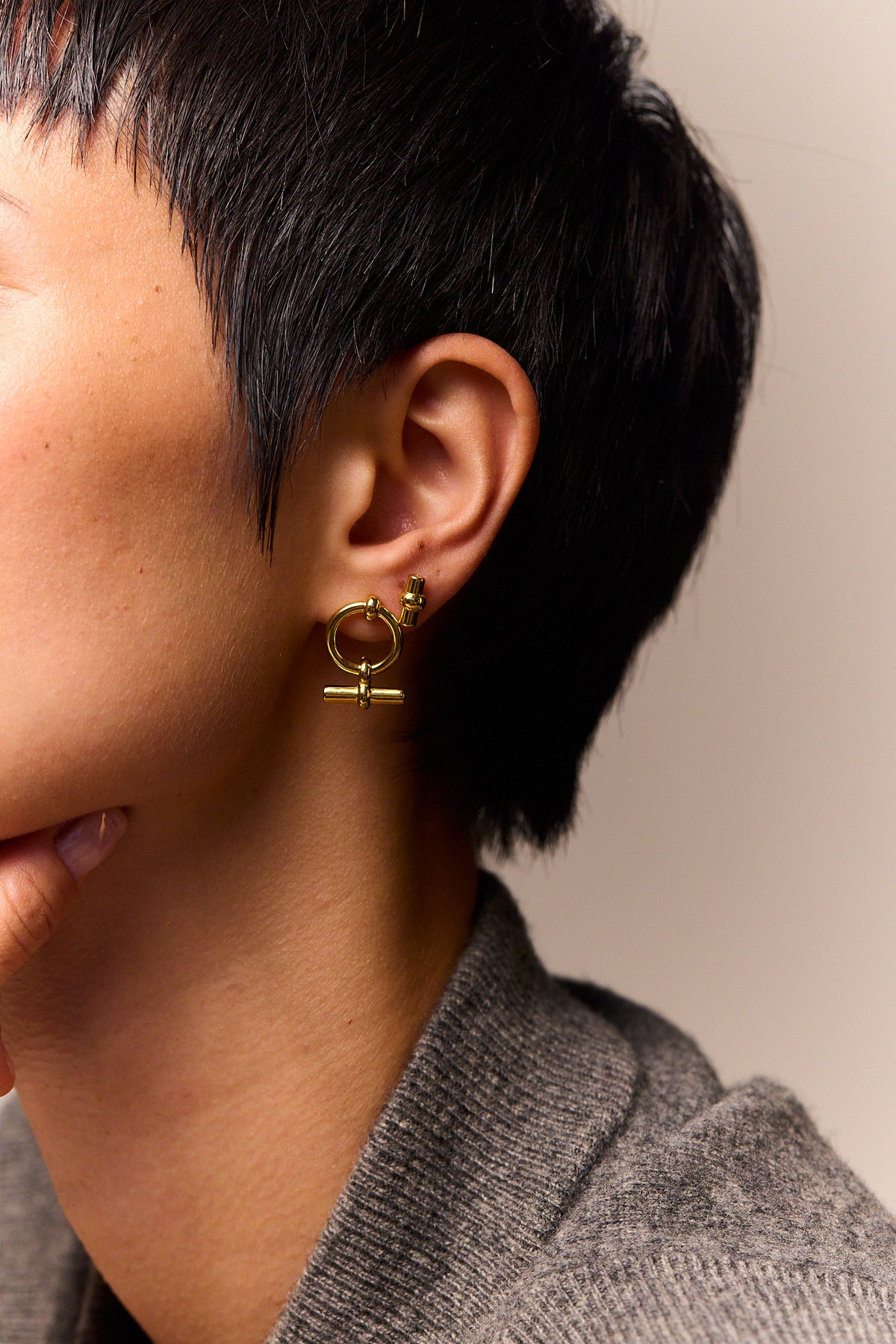 Gold T-bar stud earrings viewed from side with hinge backing