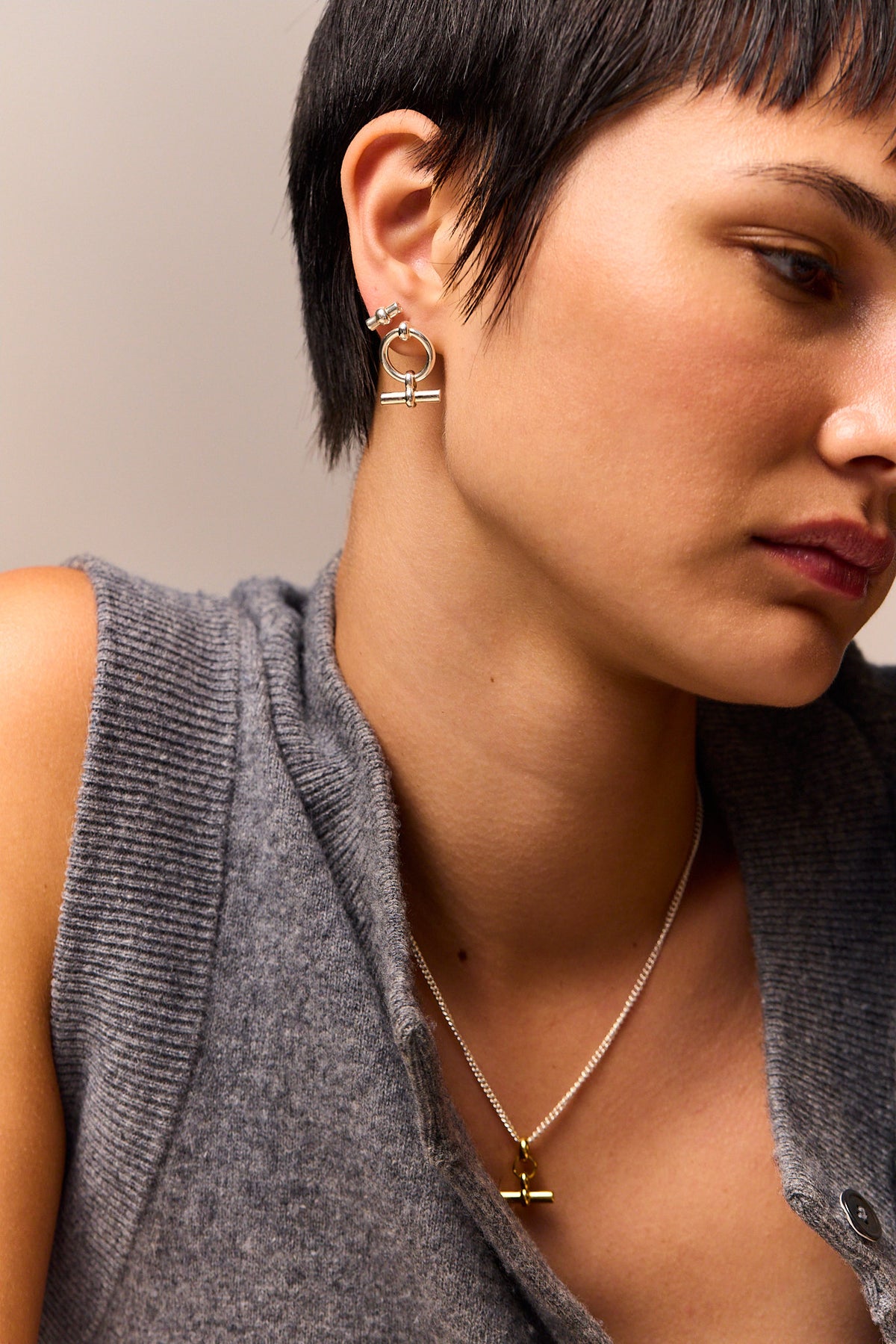 Silver T-bar stud earrings on ear, side view