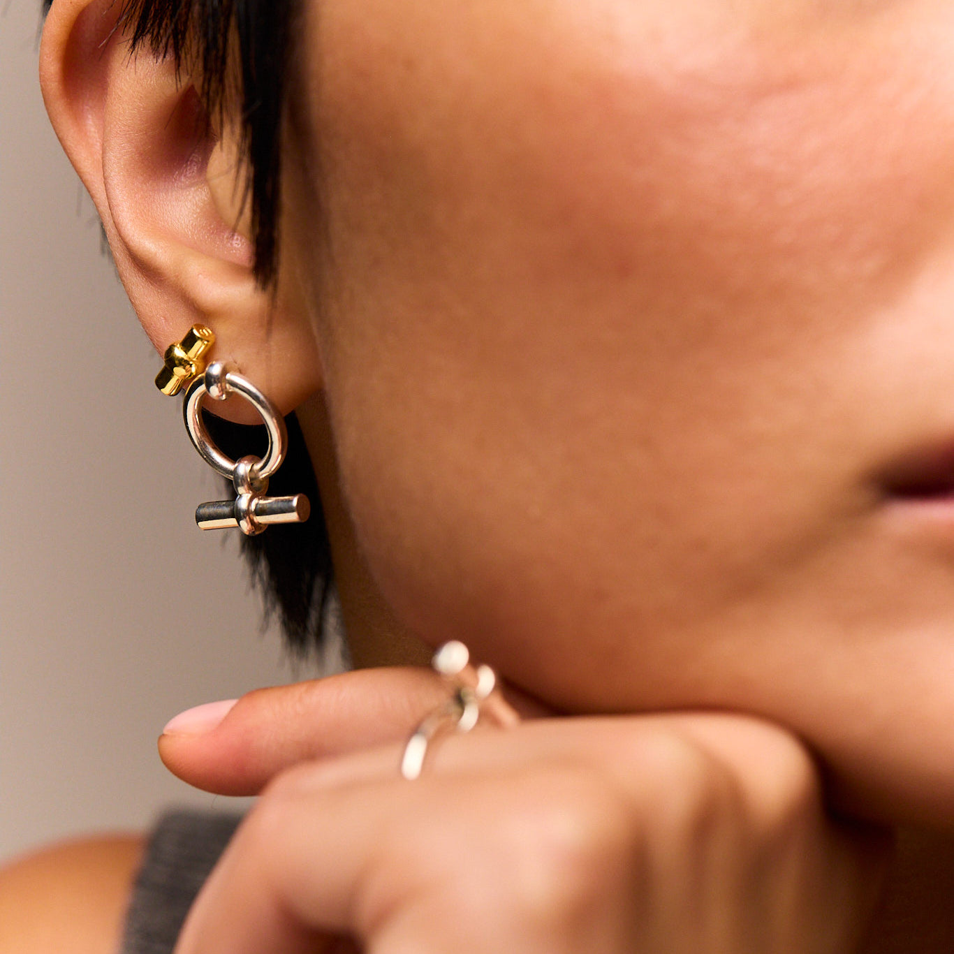 Close-up of T-bar eternity stud earring: circular ring with dangling bar