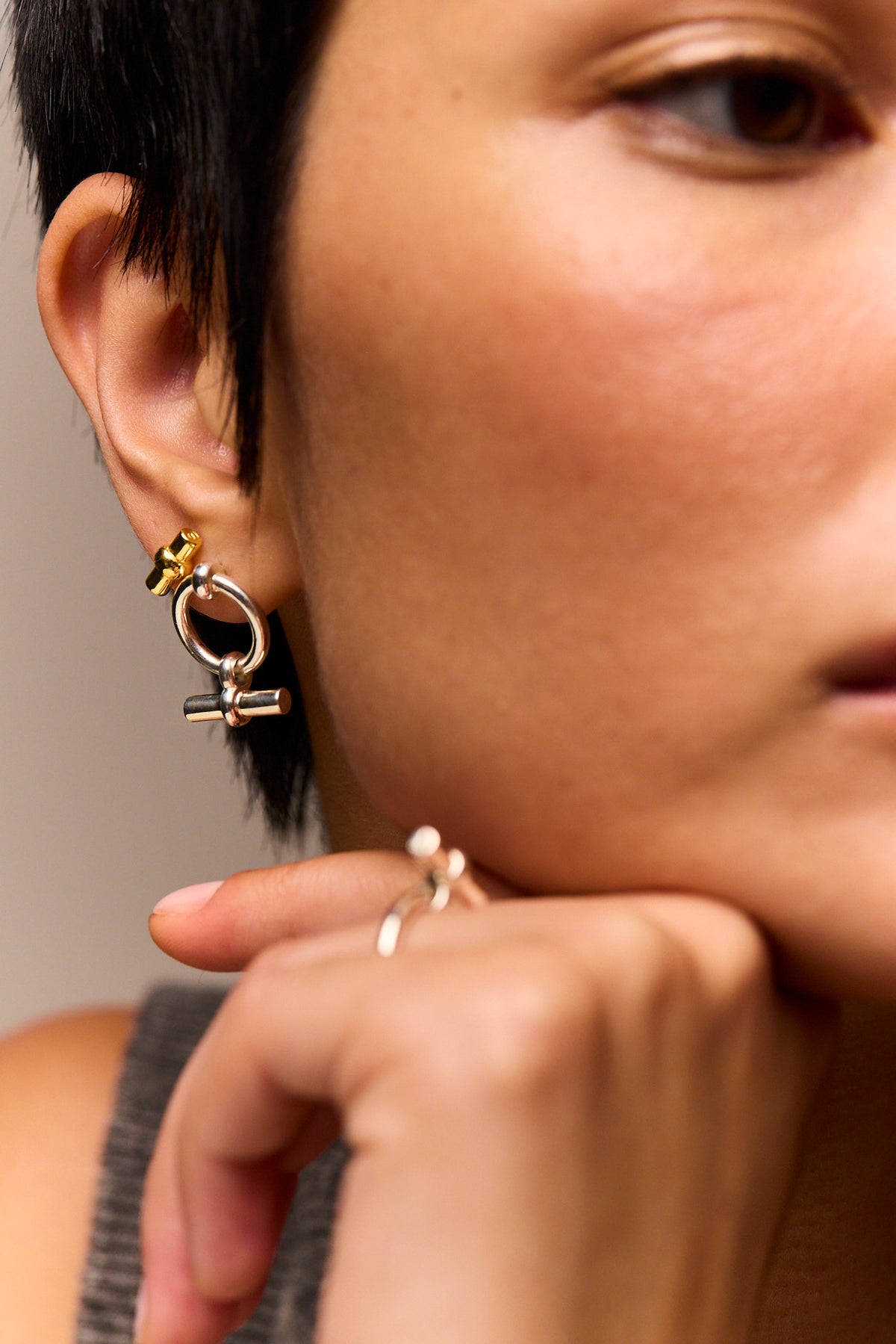 Close-up of T-bar eternity stud earring: circular ring with dangling bar
