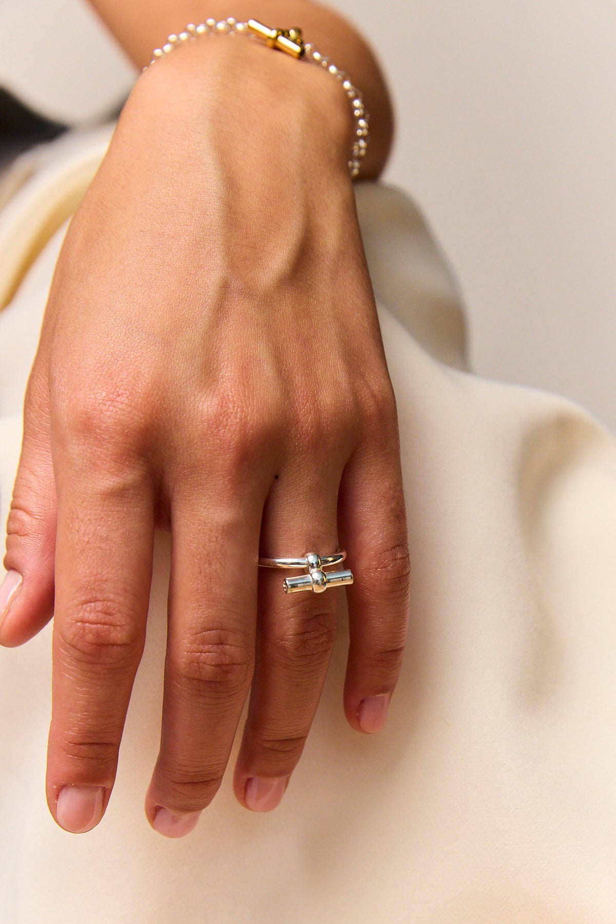 Silver T-bar eternity ring on finger, minimalist band with small top bar.