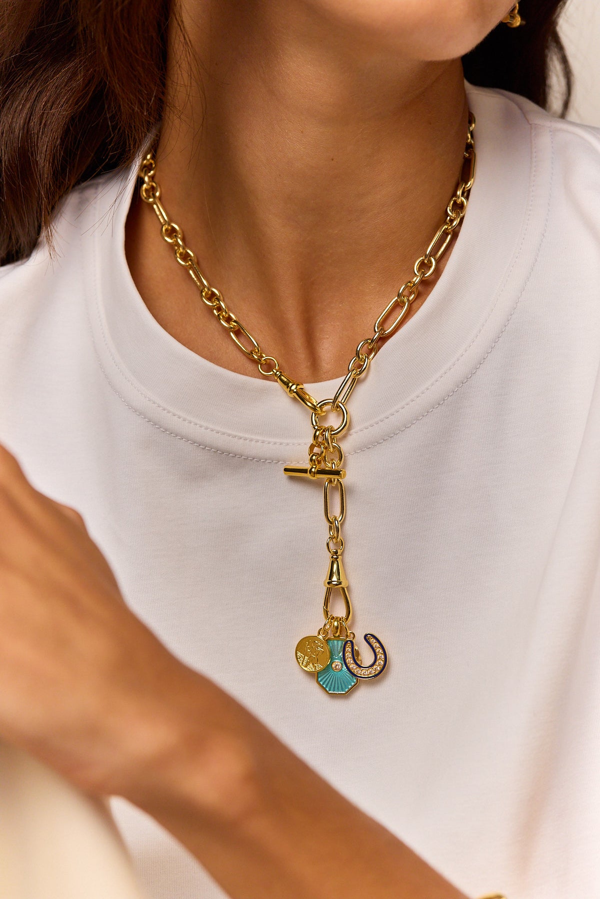 Gold chain necklace with cross charm and horseshoe pendant with turquoise enamel