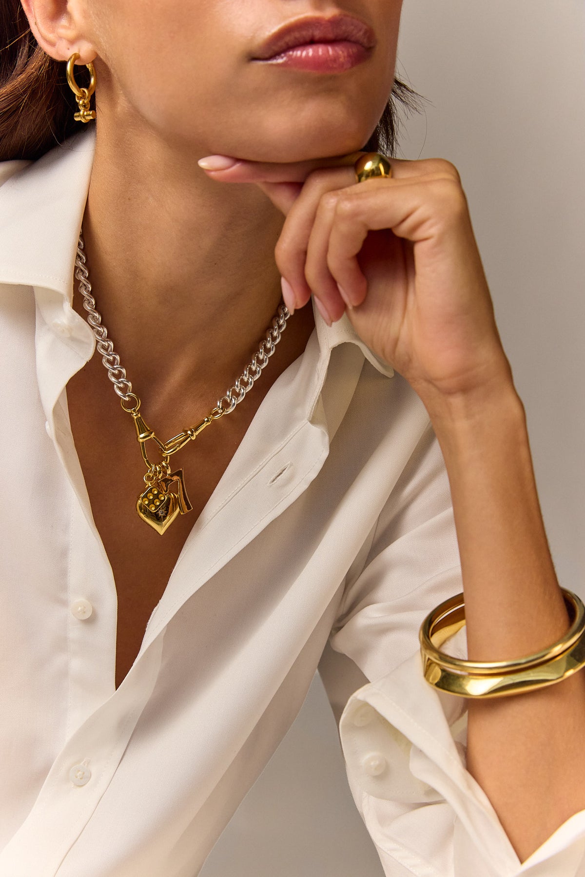 Layered charm necklace with gold heart pendant and silver chain, dangling letter charm