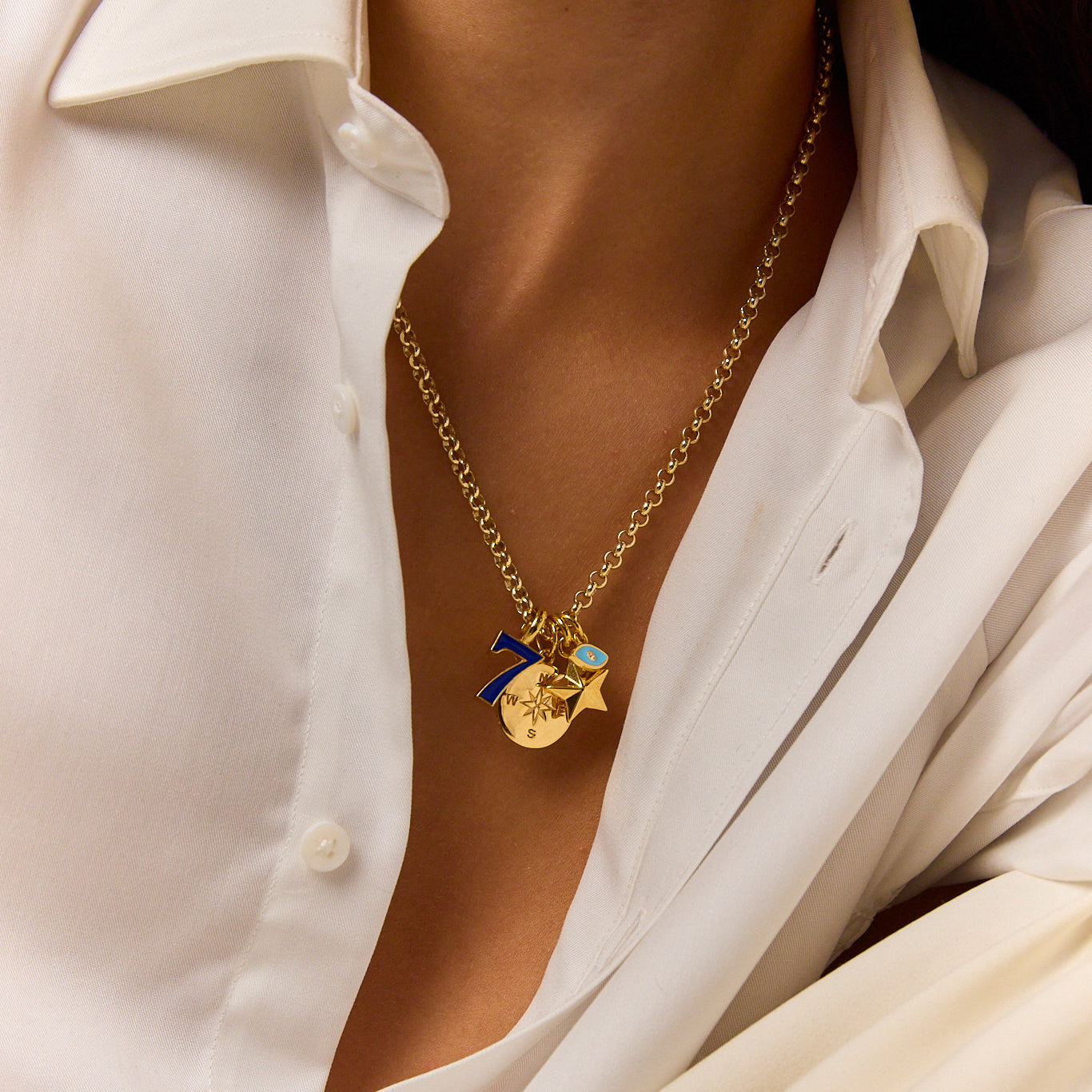 Gold-tone pendant necklace with blue eye charm and starburst pendant