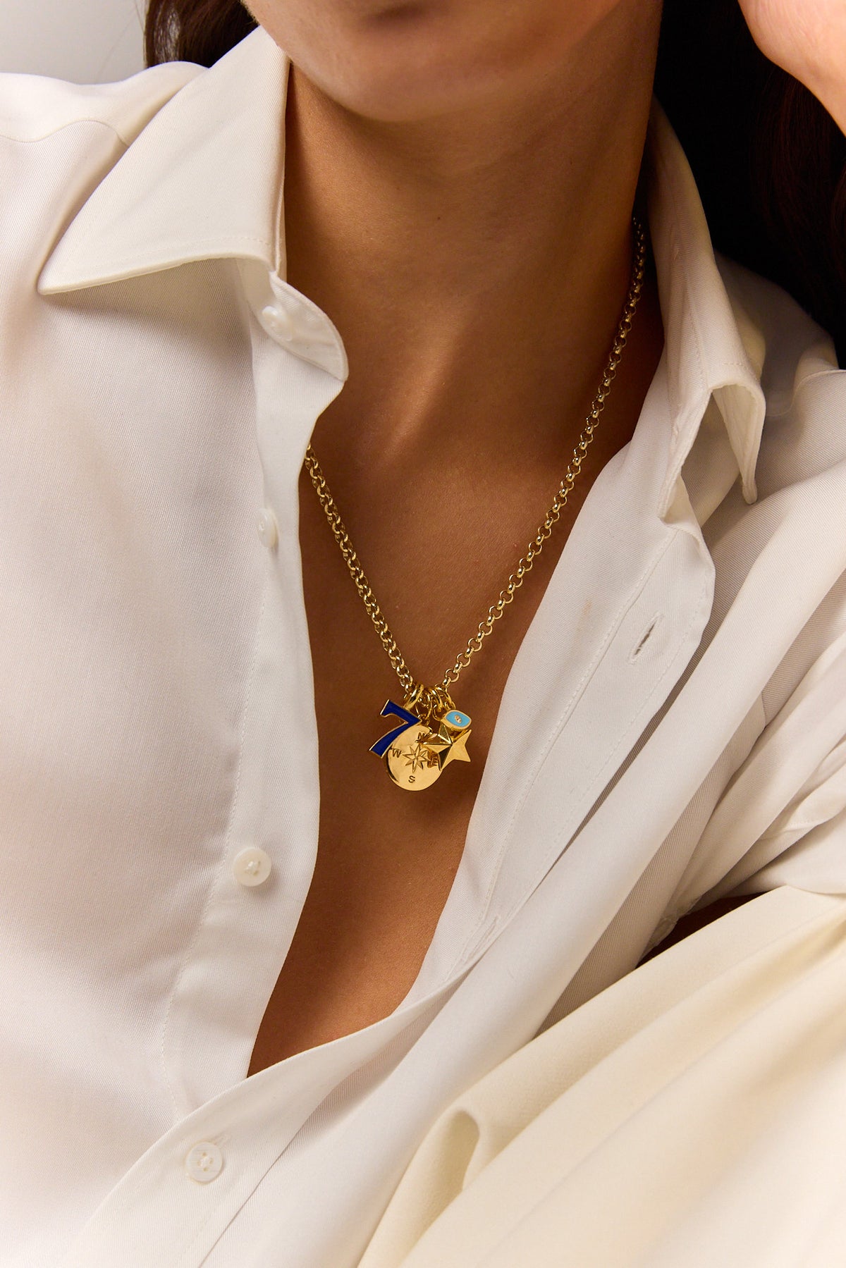 Gold-tone pendant necklace with blue eye charm and starburst pendant