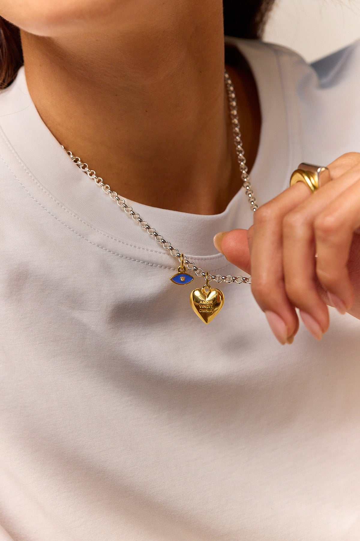 Silver chain necklace with gold heart pendant and blue eye detail