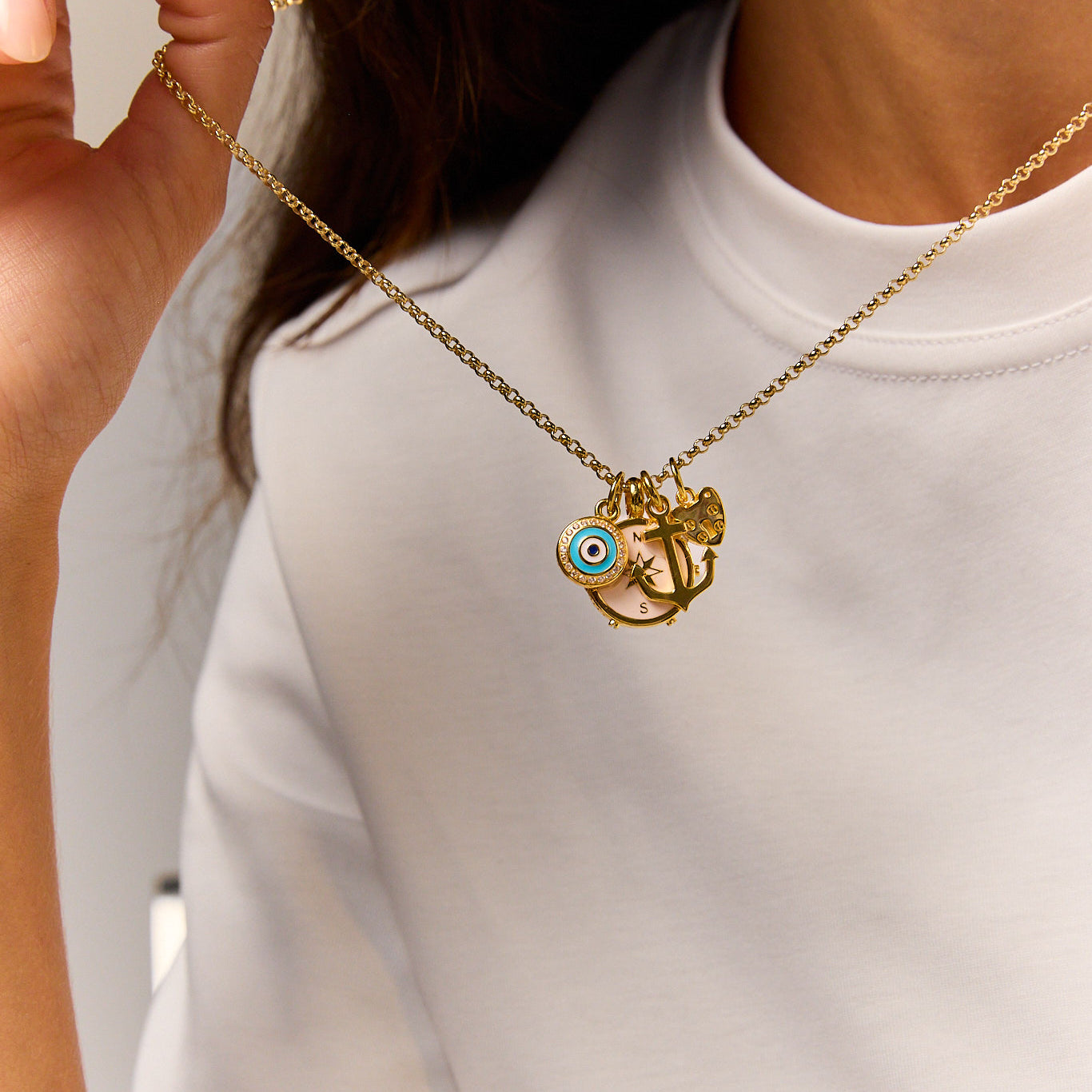 Gold-tone pendant necklace with blue evil-eye and anchor/star charms